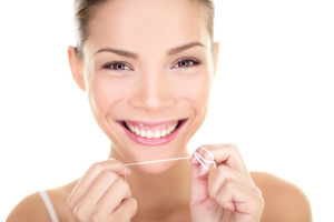 Dental flush - woman flossing teeth smiling
